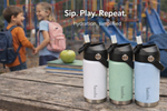 Load image into Gallery viewer, Three insulated bamba kids drink containers on a wooden surface with children playing in the background.
